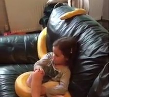 Little  Girl Watching TV with big snake on the Sofa