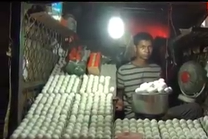 Man cooking egg omlet and giving it to customers